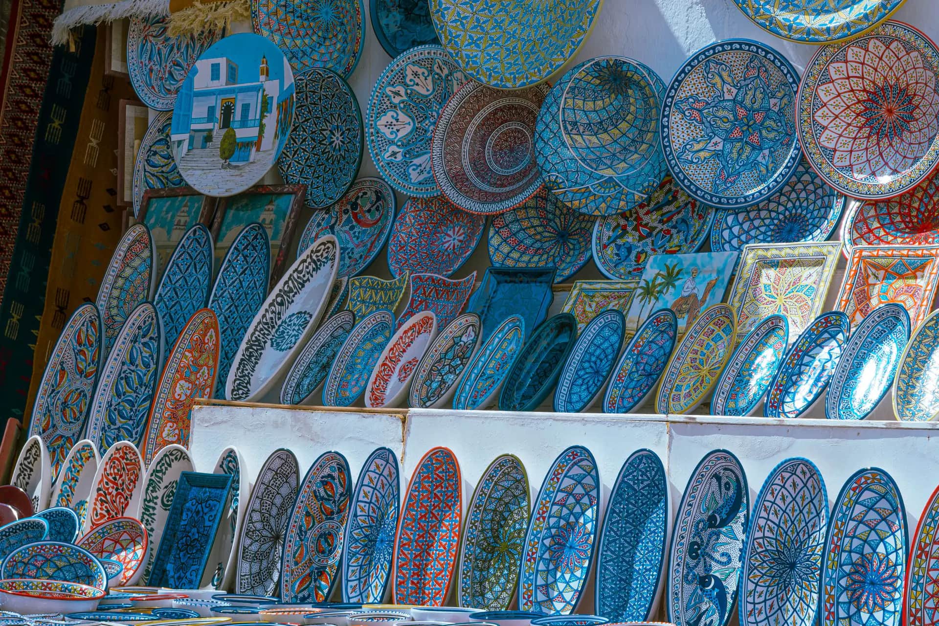 Hand-painted blue Tunisian ceramic plates on a shop display